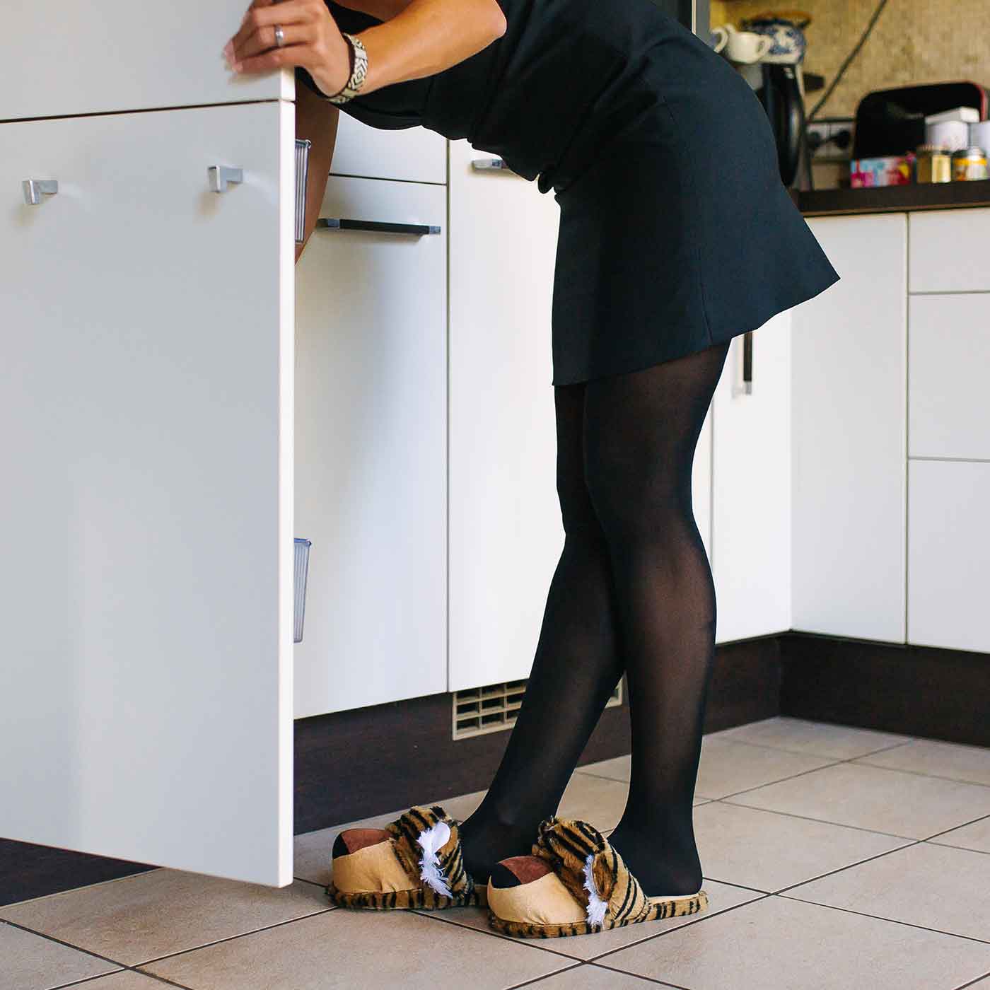Person mit Tigerpantoffeln steht am Schrank