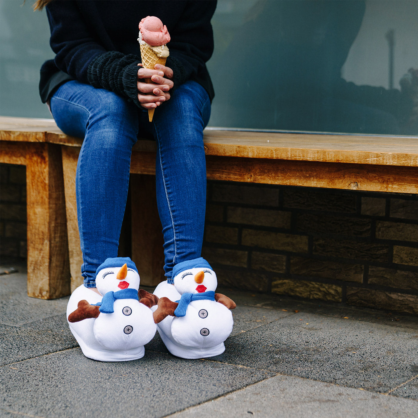 Person trägt Schneefrau Hausschuhe und iss Eis